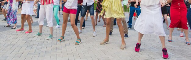 Conceito de dança e flashmob social - diversão e dança com no verão em uma rua da cidade. close-up dos pés dos dançarinos.