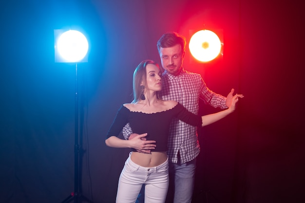 Foto conceito de dança social, kizomba, salsa, semba ou zouk - um jovem casal dançando bachata e salsa na discoteca