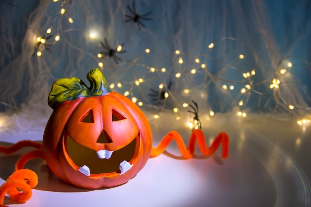 Conceito de decoração de Halloween Abóbora em uma teia com aranhas no fundo