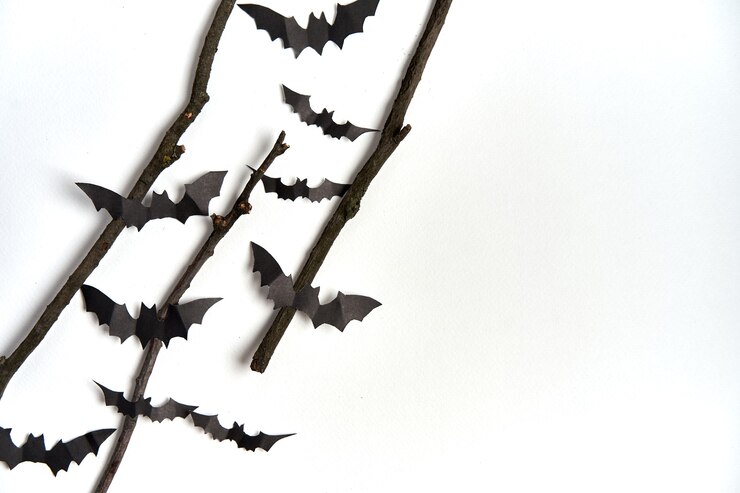 Foto conceito de decoração de halloween morcegos de papel preto galho seco vara fundo de papelão branco