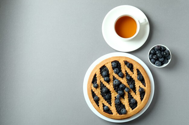 Conceito de delicioso café da manhã com torta de mirtilo em fundo cinza