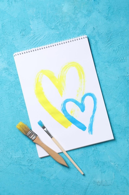 Conceito de desenho de ajuda na Ucrânia de dois corações amarelos e azuis