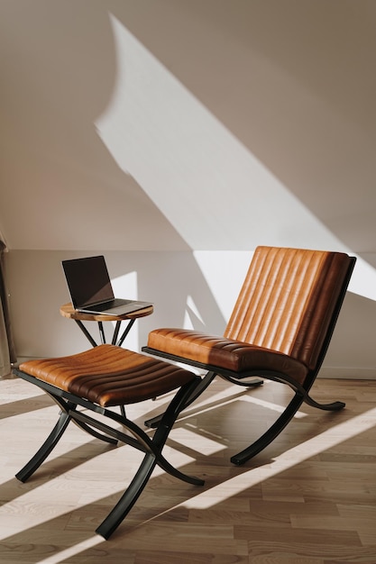 Foto conceito de design de interiores minimalista de luxo espaço de trabalho de escritório em casa escandinavo moderno e brilhante com poltrona de couro de laptop e sombras de luz solar na parede