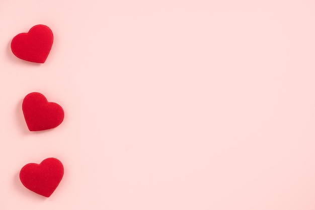 Conceito de design do dia dos namorados de coração vermelho em fundo rosa