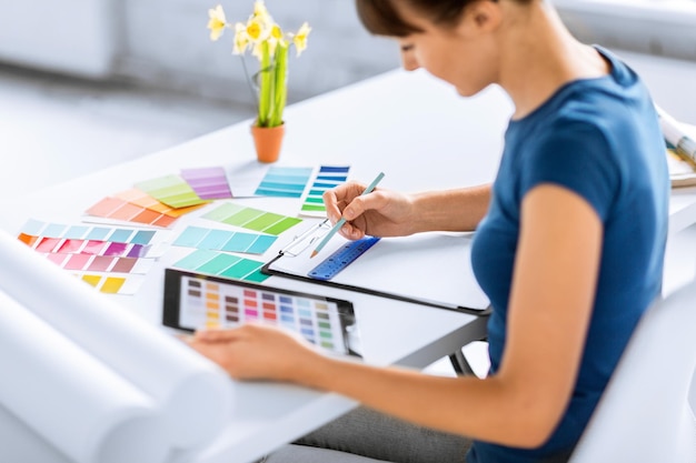 conceito de design, renovação e tecnologia de interiores - mulher trabalhando com amostras de cores para seleção