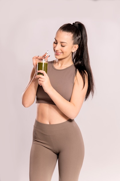 Conceito de desintoxicação, dieta saudável e fitness. jovem mulher segurando um copo com suco verde.