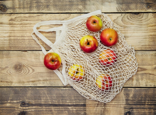 Conceito de desperdício zero, sacolas de compras de malha reutilizáveis. Sacola ecológica feita de tecido de algodão natural em um fundo de madeira.