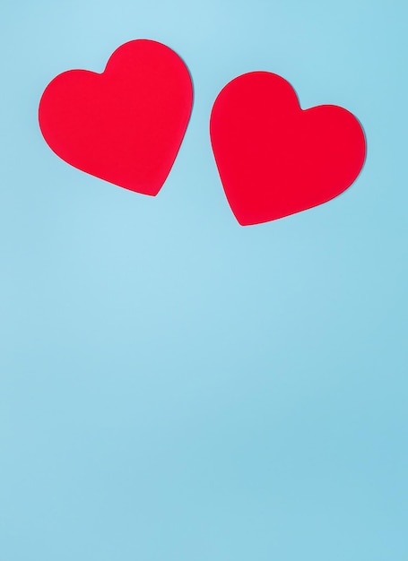 Foto conceito de dia dos namorados com dois corações vermelhos em fundo azul claro vista superior