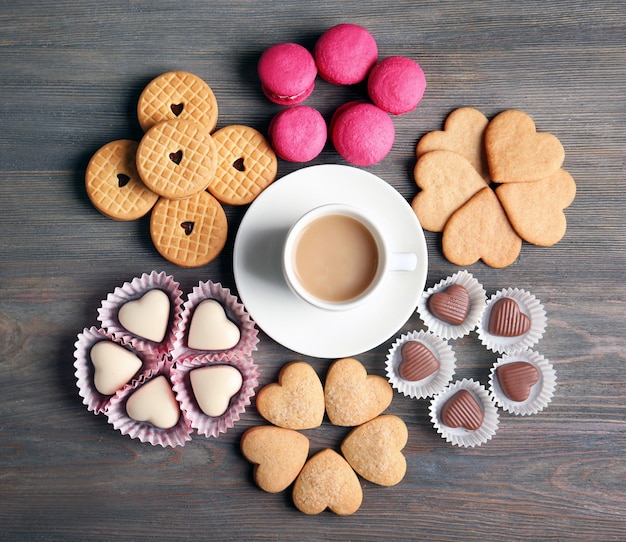 Conceito de dia dos namorados Composição de biscoitos e doces de xícara em fundo azul