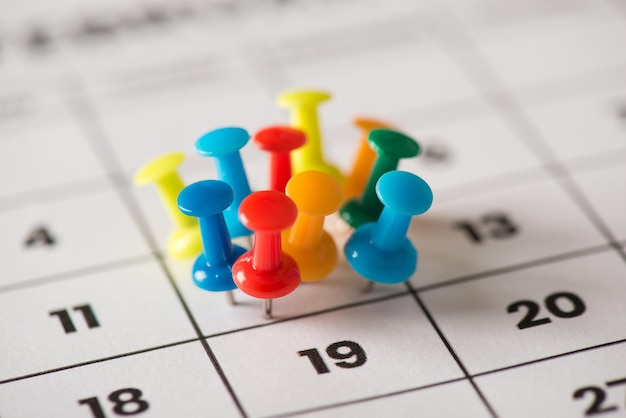 Conceito de dia ocupado. Imagem de foto de visão aproximada recortada de muitas tachinhas anexadas ao calendário