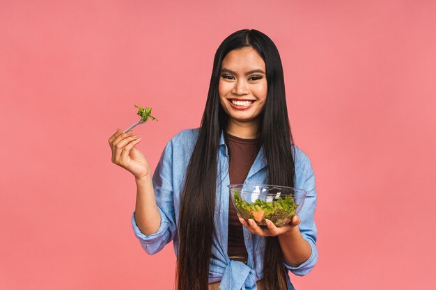 Conceito de dieta alimentar limpa Mulher asiática segurando salada vegetariana ou tigela em recipiente para viagem Feche o espaço da cópia isolado sobre o fundo rosa