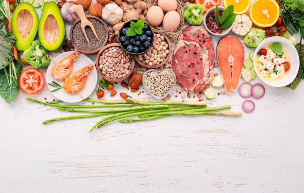 Foto conceito de dieta cetogênica com baixo teor de carboidratos ingredientes para seleção de alimentos saudáveis configurados em fundo branco de madeira