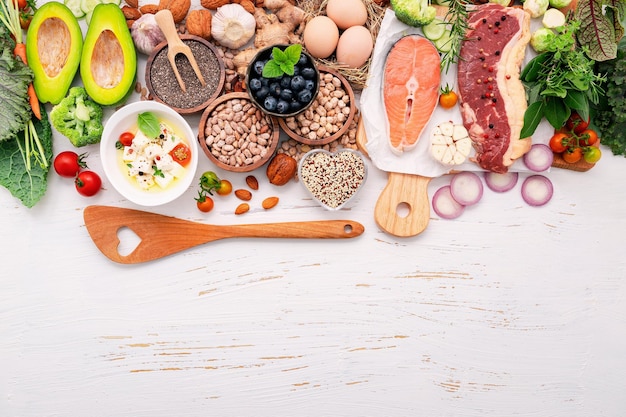 Foto conceito de dieta cetogênica com baixo teor de carboidratos ingredientes para seleção de alimentos saudáveis configurados em fundo branco de madeira