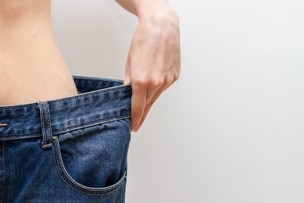 Conceito de dieta e perda de peso. mulher em calça jeans oversize.