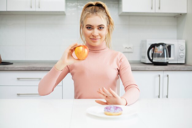 Conceito de dieta. jovem mulher escolhendo entre frutas e doces