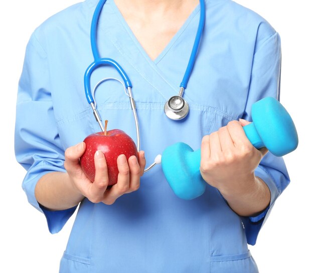 Foto conceito de dieta nutricionista feminina com maçã e halteres em fundo branco