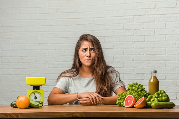 Foto conceito de dieta. retrato de uma mulher jovem e saudável latina duvidando e confuso, pensando em uma idéia ou preocupado com algo