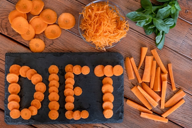 Conceito de dieta vegetal e saúde Diferentes cortes de cenoura na mesa de madeira dieta na tábua