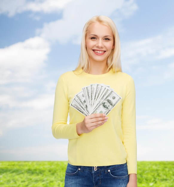 conceito de dinheiro, finanças e pessoas - garota sorridente com dinheiro em dinheiro dólar