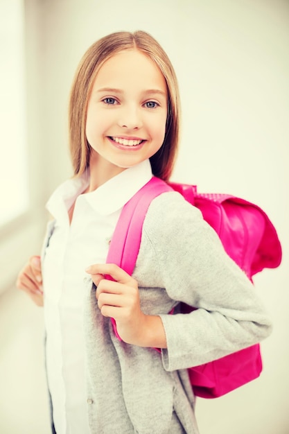 conceito de educação e escola - adolescente feliz e sorridente com mochila escolar
