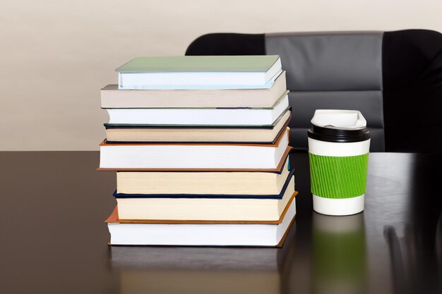 Foto conceito de educação e literatura com uma xícara de café e livros na mesa em uma sala de aula vista superior e espaço de cópia com foco seletivo