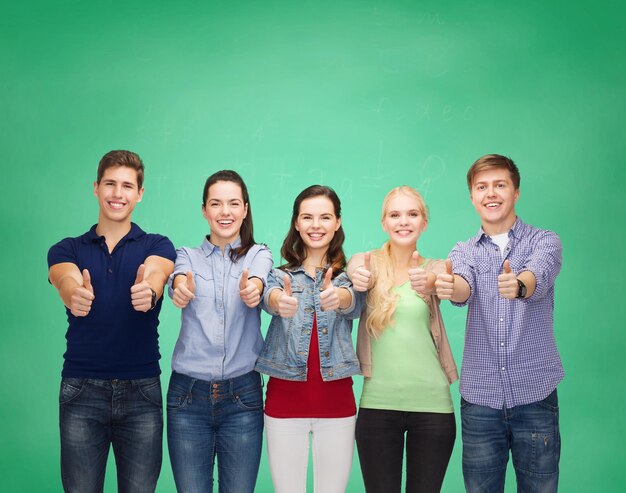 conceito de educação e pessoas - grupo de estudantes sorridentes em pé e mostrando os polegares para cima