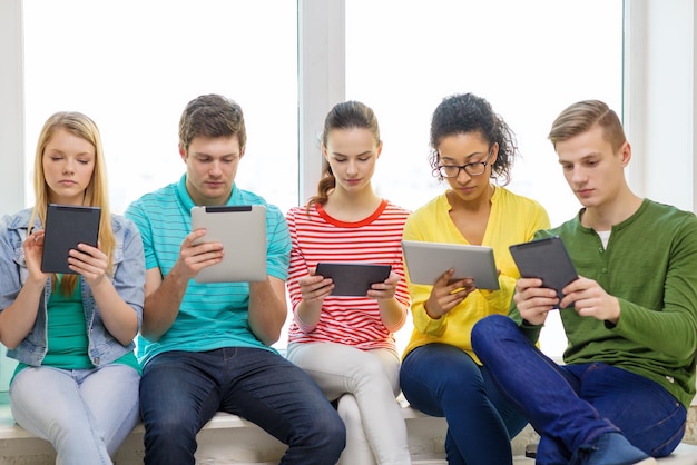 conceito de educação e tecnologia - alunos sorridentes com computador tablet pc na escola