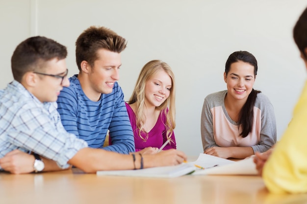 conceito de educação, escola, arquitetura e pessoas - grupo de estudantes sorridentes com reunião de planta dentro de casa