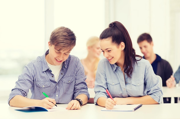 conceito de educação, escola e pessoas - dois adolescentes com notebooks na escola