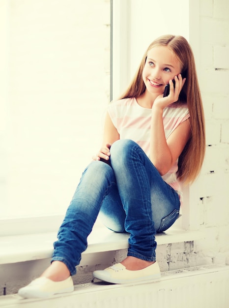 conceito de educação, escola, tecnologia e internet - menina aluna com smartphone na escola