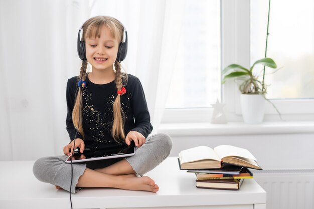 conceito de educação, escola, tecnologia e internet - menina estudante com tablet pc em casa