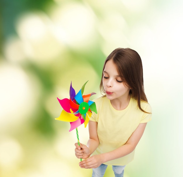 conceito de educação, infância e ecologia - criança sorridente com brinquedo colorido moinho de vento