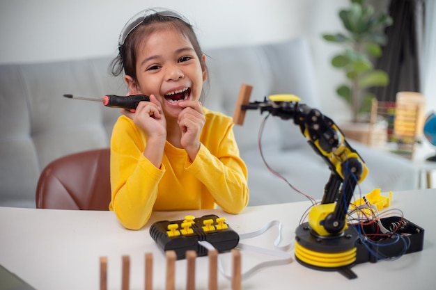 Conceito de educação STEM Estudantes asiáticos aprendem em casa codificando braços robóticos em código de computador de tecnologia científica de engenharia matemática STEM em robótica para conceitos infantis