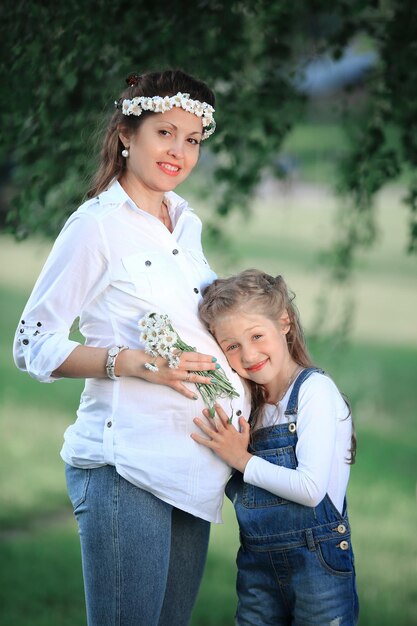 Conceito de educação uma mãe grávida e sua filha pequena