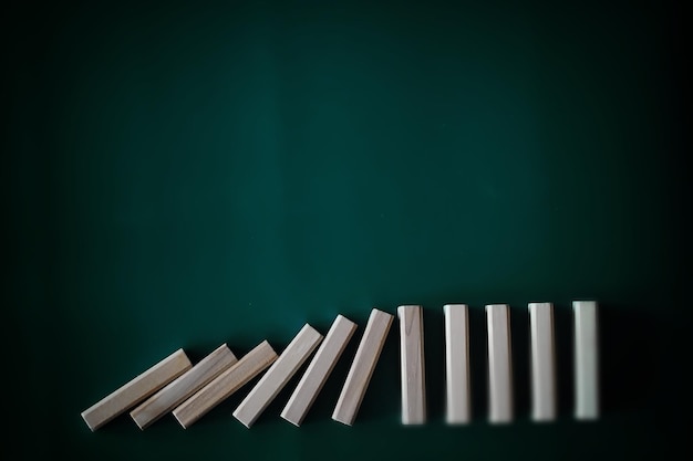 Foto conceito de efeito dominó com telhas de madeira bloqueadas por ampulheta com fundo