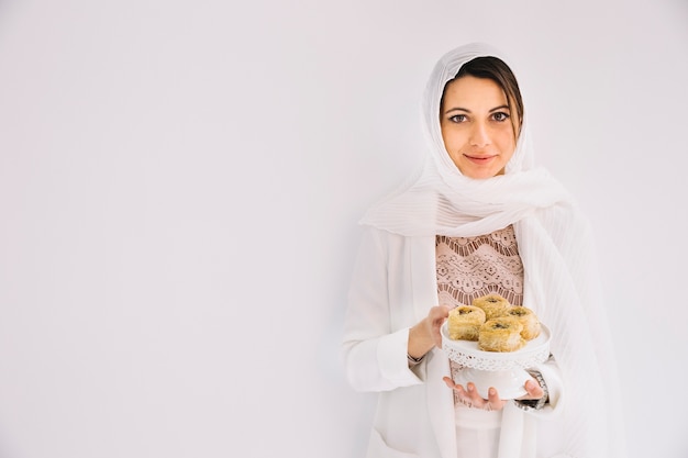 Conceito de Eid com mulher segurando doces árabes