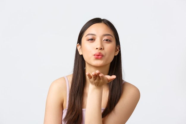 Conceito de emoções de beleza, moda e pessoas. Retrato de close-up de uma linda garota romântica e coquete em um vestido