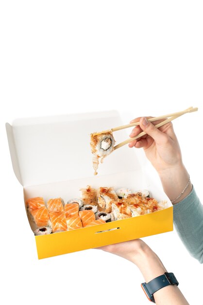 Conceito de entrega de sushi, menina segurando conjuntos de sushi em um recipiente de papel descartável, caixas de papel ecológicas