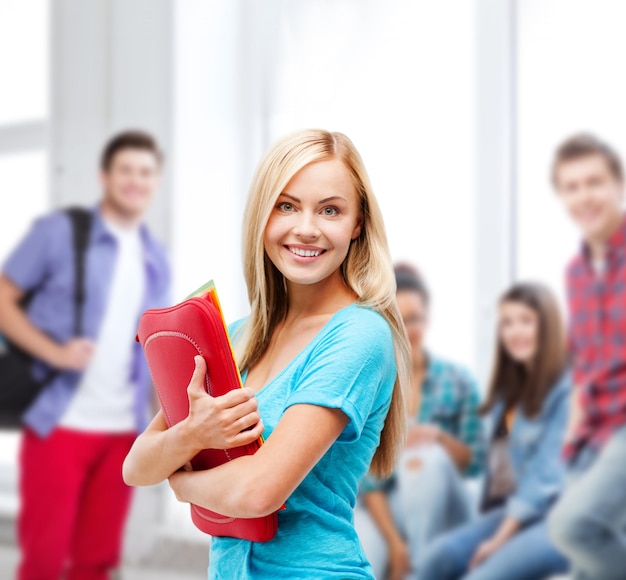 conceito de escola e educação - estudante sorridente com pastas