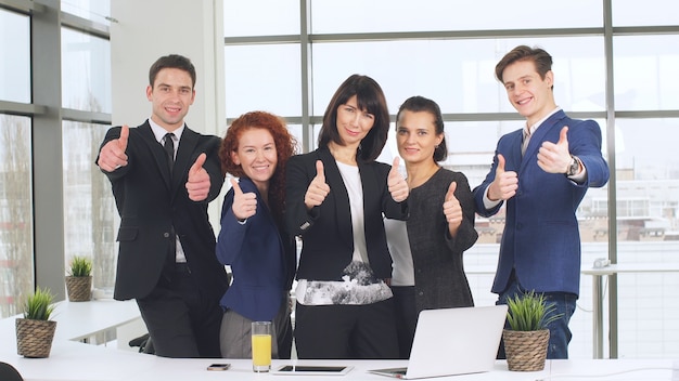 Conceito de escritório e trabalho em equipe, grupo de pessoas de negócios, tendo uma reunião e mostrando polegares para cima.