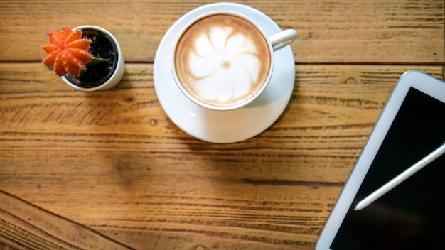 Conceito de escritório vista de cima de tela preta tablet e caneta cacto e uma xícara de café para rela