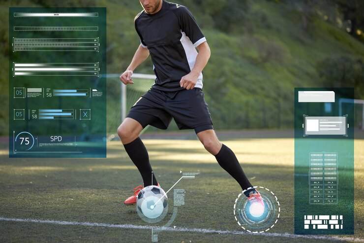 Foto conceito de esporte, tecnologia e pessoas - jogador de futebol jogando com bola no campo de futebol