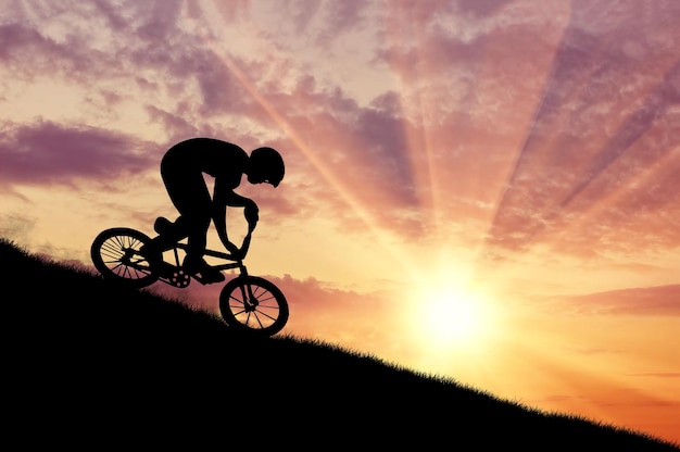 Foto conceito de esportes radicais. silhueta de um ciclista se movendo ao pôr do sol