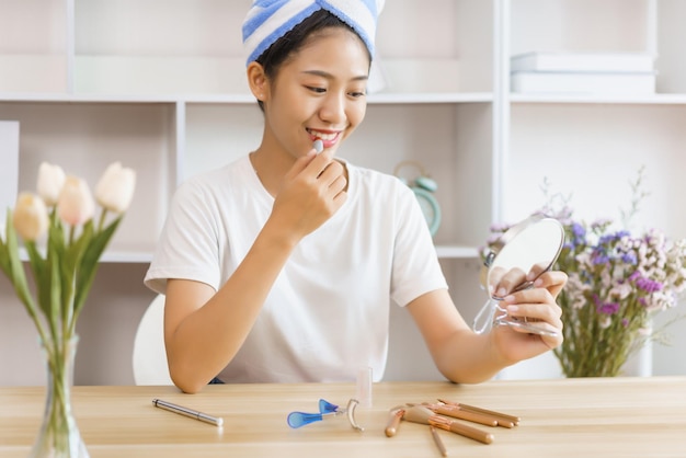 Conceito de estilo de vida aconchegante Jovem em turbante após o banho e usa batom para maquiagem em casa