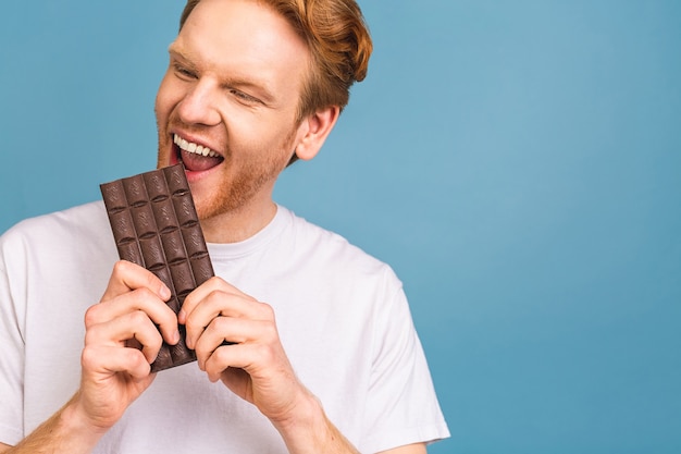 conceito de estilo de vida de emoções sinceras de pessoas. mock up cópia espaço. segurando, mordendo a barra de chocolate