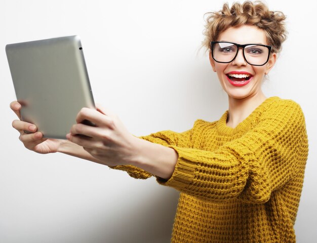 Conceito de estilo de vida e pessoas: mulher feliz tirando uma selfie com tablet digital