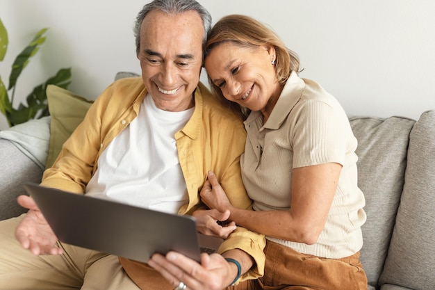 Foto conceito de estilo de vida e tecnologias de aposentadoria feliz chamadas de vídeo para cônjuges sênior usando laptop