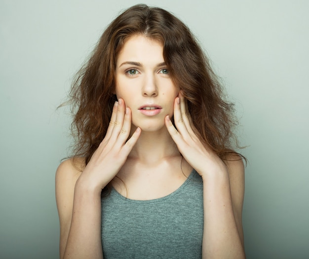 Conceito de estilo de vida, moda e pessoas: jovem mulher encaracolada, posando no estúdio, estilo casual, adolescente.