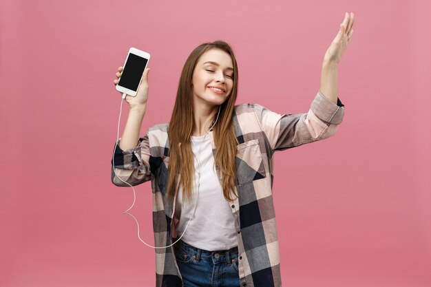 Conceito de estilo de vida. Mulher jovem usando o telefone para ouvir música