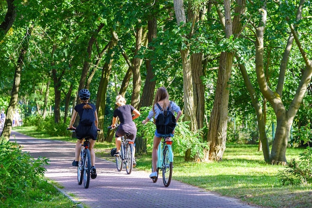 Conceito de estilo de vida saudável ciclismo familiar desconhecido no parque público em um dia ensolarado